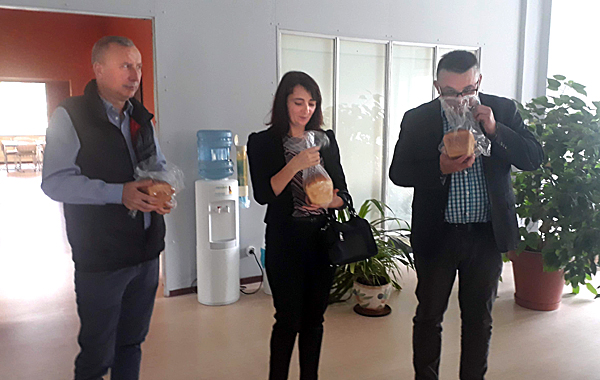 Wizyta w Laboratorium. Na zdjęciu prof. dr hab. Karol Wolski, dr hab. Tetiana Sladkowska i dr inż. Michał Rębarz z bochenkami chleba