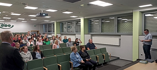 Zdjęcie 3 Wykłady w Centrali COBORU cz2 grupa ok 40 osób na sali wykładowej oraz pracownicy COBORU przedstawiają program spotkania